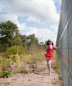 Pale-skinned brunette parts with dress and panties outdoors